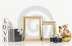 Golden picture frame, rose flowers and vintage camera. Retro sty