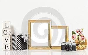 Golden picture frames, roses flowers and vintage camera. Retro d