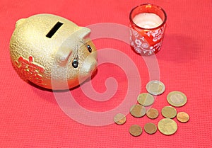golden piggy bank, coins and a candle