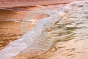 Golden pink sunrise on the beach, peaceful waves