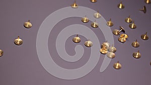 Golden pins falling on grayish background . stationery concept. copy space. isolated