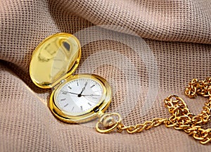 Golden pocket watch on fabric