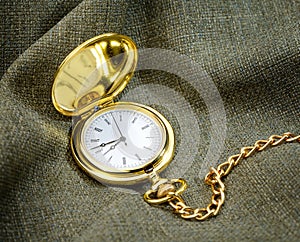Golden pocket watch on fabric