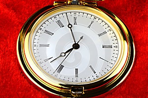 Golden pocket watch on red velvet