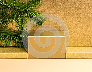 Golden podium for product presentation on beige and luxury glitter gold background, fir tree branch. Winter festive