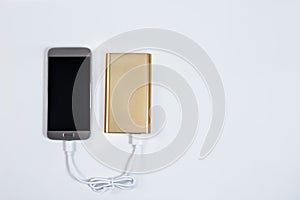 Golden powerbank with smart phone on background