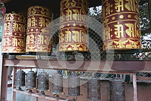 Golden prayer wheels with tibetan mantra `Om Mani Padme Hum` written on it, which means: The Jewel is in the Lotus. Prayer wheels