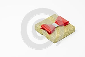 Golden present box with a red bow