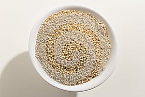 Golden Quinoa seed. Top view of grains in a bowl. White background.