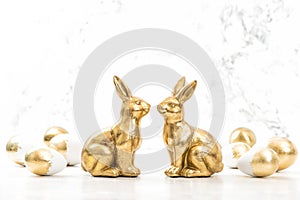 Golden rabbits Easter eggs white background