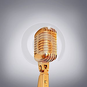 Golden retro microphone on grey background.