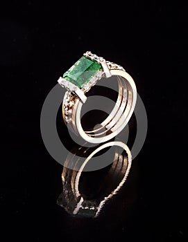 Golden ring with emerald diamond brilliant