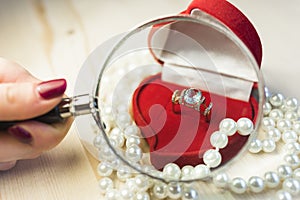 Golden ring with gem in a red gift box with pearls