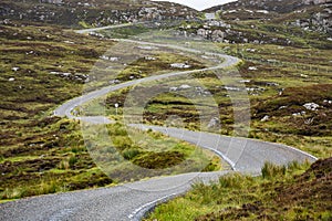 Golden road winding through the Scottish rocky landscape