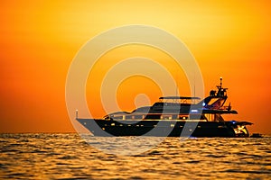 Golden romantic sunset on private modern luxury yacht anchored at sea - luxury holidays and travel concept. A red