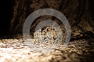 Golden royal crown on velvet fabric background. Jewellery