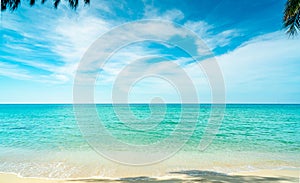 Golden sand beach by the sea with emerald green sea water and blue sky and white clouds. Summer vacation on tropical paradise