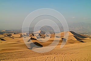 Golden sand dunes with the wheel prints of dune buggies, Huacachina, Ica, Peru