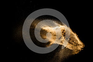 Golden sand explosion isolated on black background. Abstract sand cloud. Golden colored sand splash against dark background.