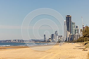 Golden sand of the Main Beach on the Gold Coast with the Surfers Paradise tourism destination city skyline in the distance, view