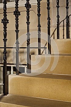 Golden sandstone steps and ornate black stair banister posts