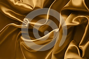 Golden satin fabric with large folds, abstract background