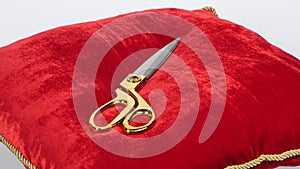 Golden scissors to open shop on red pillow. Rotation. White