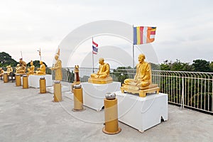 golden sculptures of elderly buddhists near the big buddha statue on phuket island in thailand