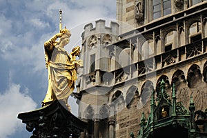 Golden scuplture of Virgin Mary at  Marienplatz under blue sky backgrounds, Munich, Germany, Travel photo