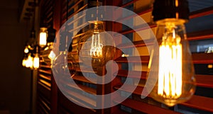 Golden shining antique Edison style bulbs in the dark. Lighting decor concept. Blur background of retro lights