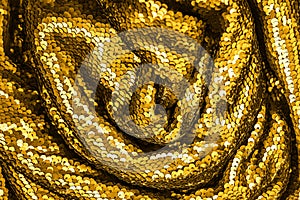 Golden shiny fabric with sequins, abstract background