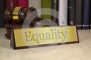 Golden sign with gavel and the word Equality on a desk