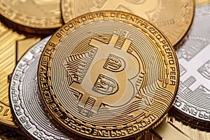 Golden and silver bitcoin coins, close-up.
