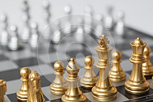 Golden and Silver chess surrounded by a number of fallen chess pieces, business strategy, chess battle, victory, success, teamwork