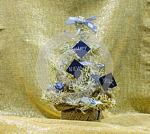 Golden and silver Christmas tree with black cards that say Happy