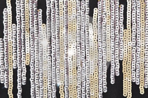 Golden and silver sequins on black fabric, glamour shiny background, bright creative decor,  glitter grey backdrop, fashionable
