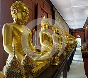 Golden sitting Buddha sculpture line in the pavillion
