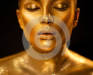 Golden skin woman face. Fashion art portrait closeup. Model girl with holiday golden glamour shiny professional makeup