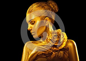 Golden skin woman with rose. Fashion art portrait. Model girl with holiday golden glamour shiny professional makeup