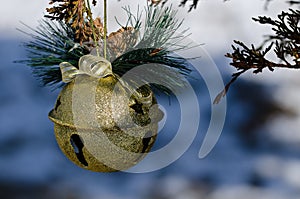 Golden Sleigh Bell Christmas Ornament Decorating an Outdoor Tree