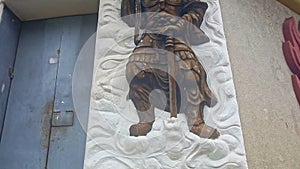 Golden Soldier Bas-Relief on White Panel of Building Wall