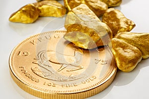 Golden south african krugerrand one ounce coin laying on a heap of golden nuggets, golden ore