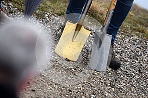 A golden spade at a groundbreaking ceremony for a building