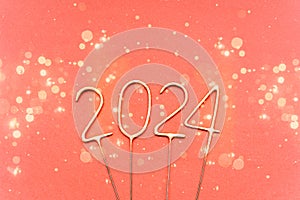 Golden sparklers in the form of the numbers 2024 on a red background