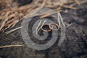 Golden sparkling glitter bokeh background with golden wedding rings and copy space. Shallow focus.