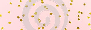 Golden star sprinkles on pink. Festive holiday background. Celeb