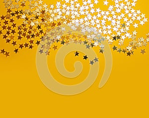 Golden stars confetty on yellow background