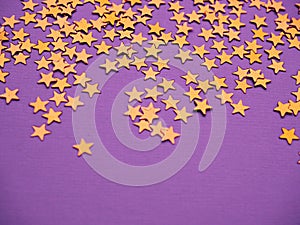 Golden stars glitter on lavender paper background