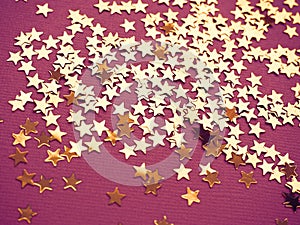 Golden stars glitter on lavender paper background