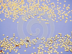 Golden stars glitter on lavender paper background